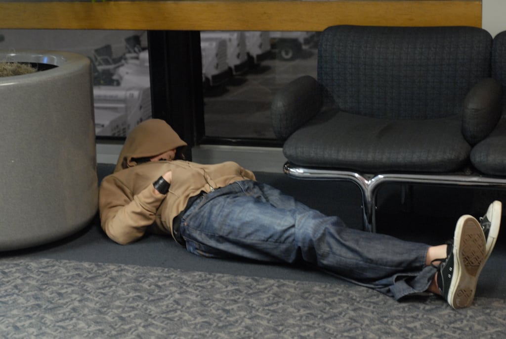 A man sleeps while stuck at an airport.