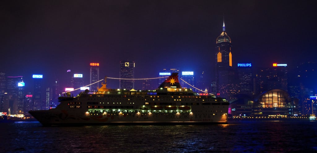 A cruise ship floats by Central Plaza in Victoria Harbour in Hong Kong.