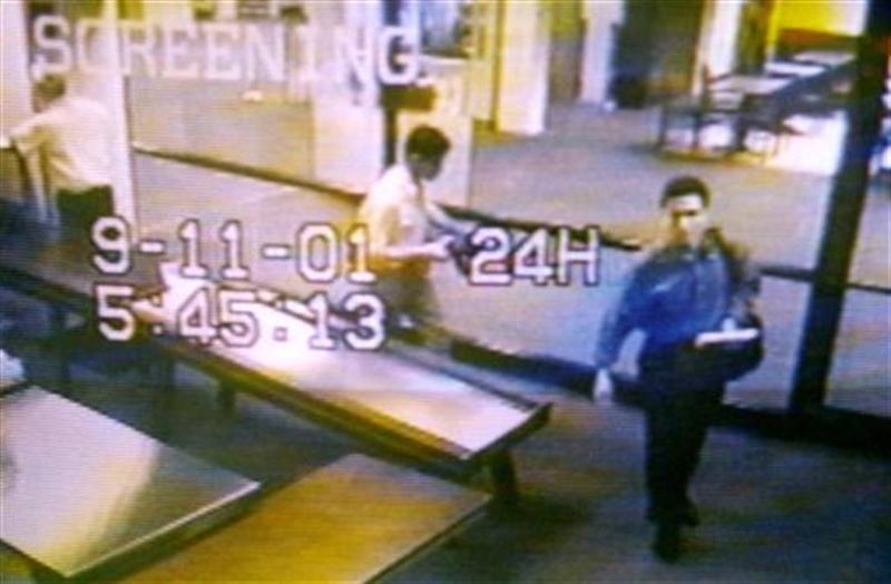Two men identified by authorities as suspected hijackers Mohammed Atta (R) and Abdulaziz Alomari (C) pass through airport security September 11, 2001 at Portland International Jetport in Maine in an image from airport surveillance tape released September 19, 2001. 
