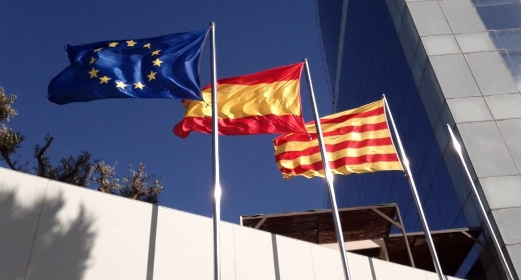 EU, Spain, and Catalonia flags fly in Barcelona. 