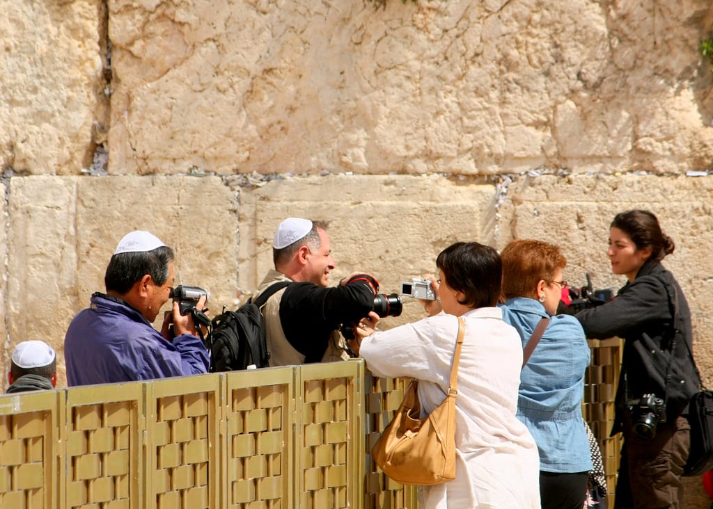 Tourists photographing each other over the mechitza (barrier between the men's and women's side) at the Western Wall.