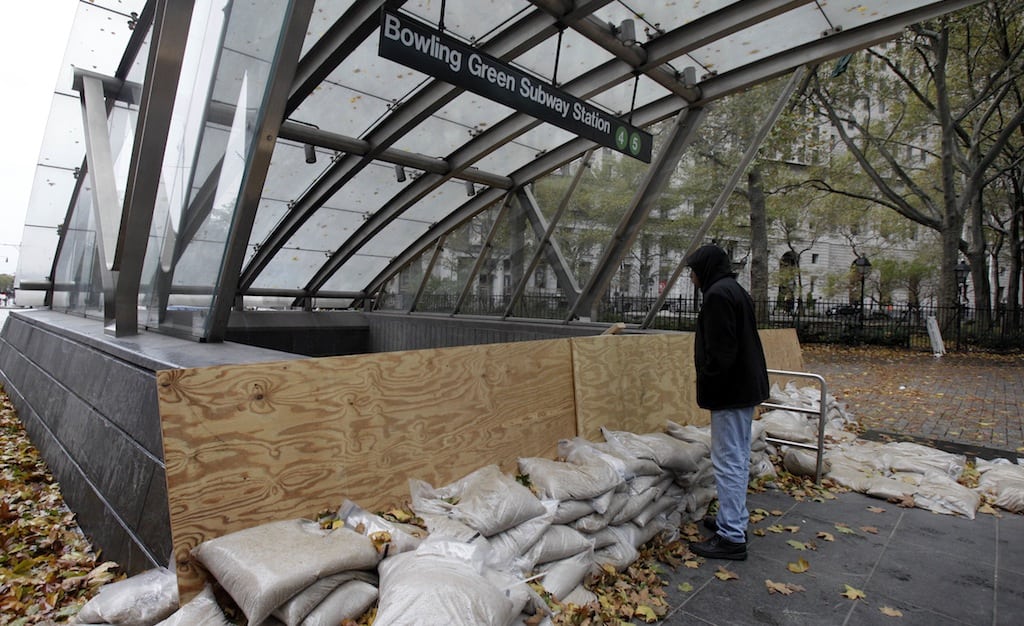 Man peering into the closed Bowling Green subway station in New York, after Superstorm Sandy his the east Coast.