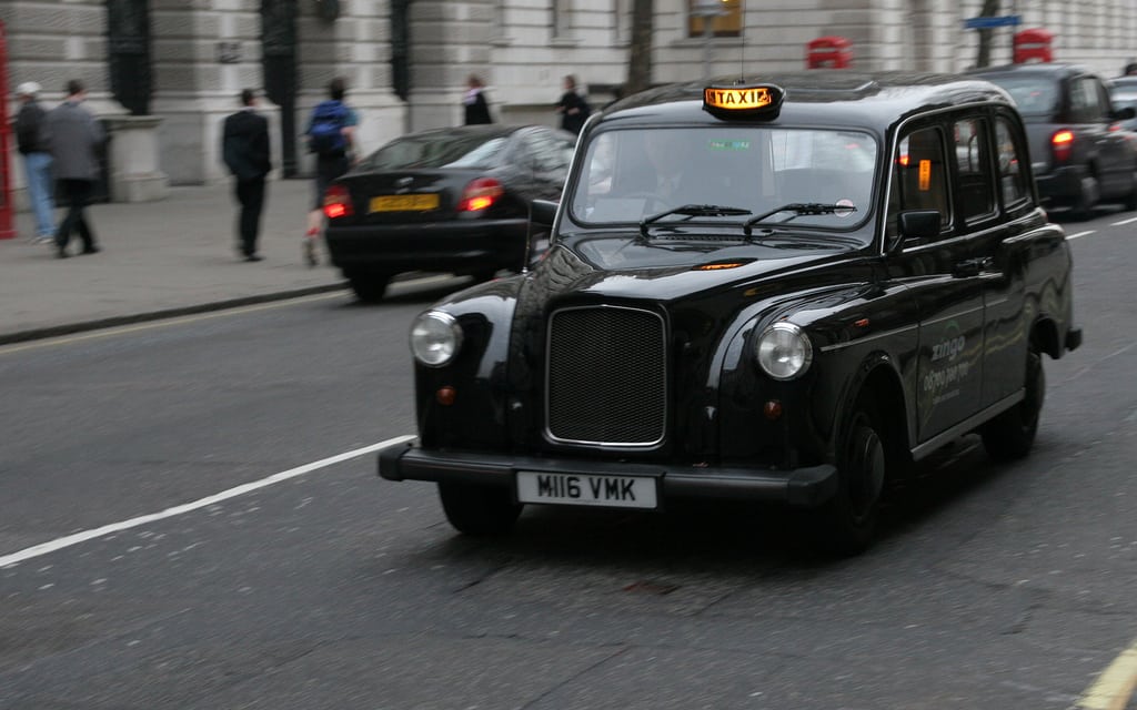 A black cab drives through London. 