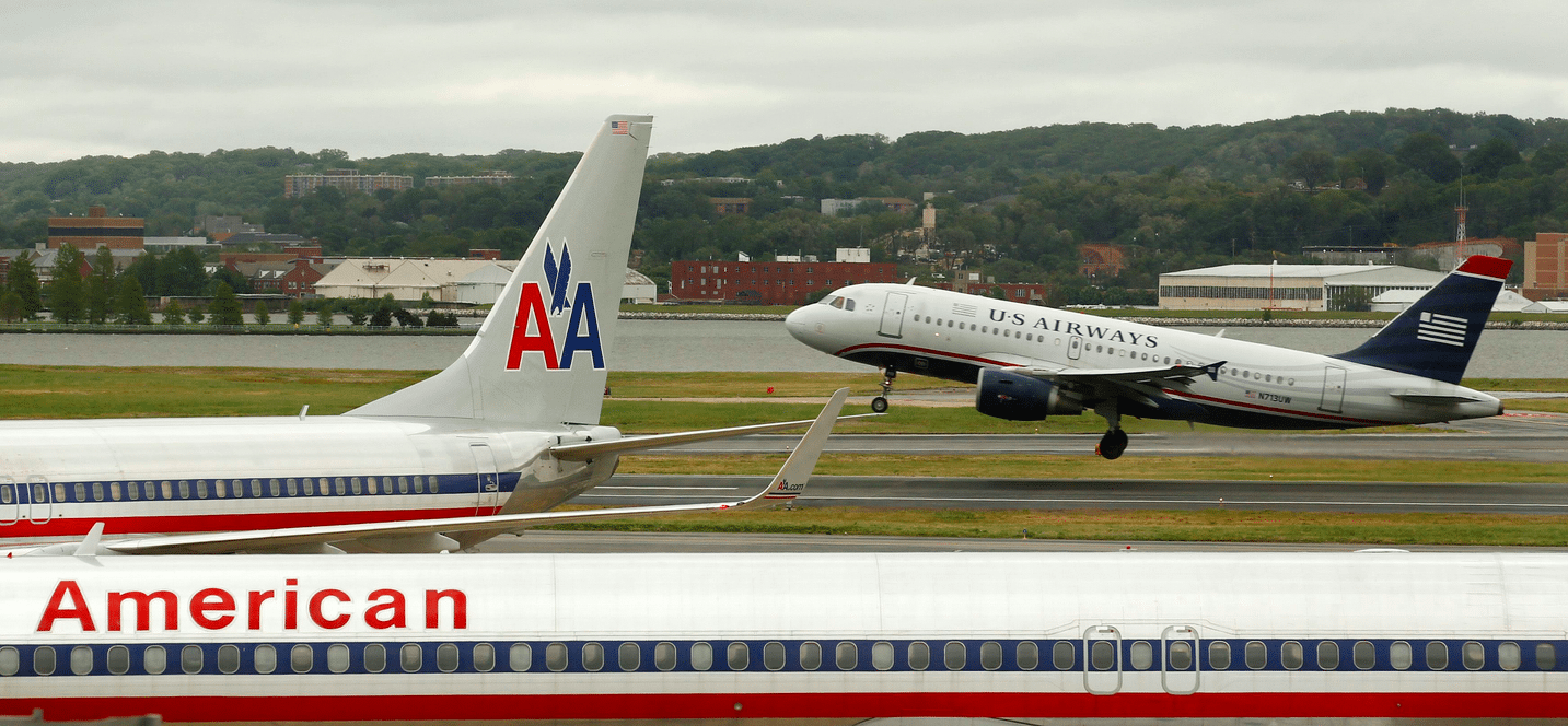 A US Airways plane takes off behind an American Airlines jet at Ronald Reagan National Airport in Washington. 