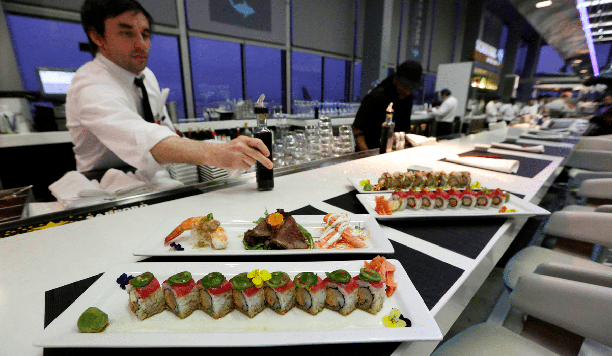 A waiter delivers plates of fresh sushi at Wicker Park Seafood & Sushi in Terminal 2 at O'Hare International Airport in Chicago. 