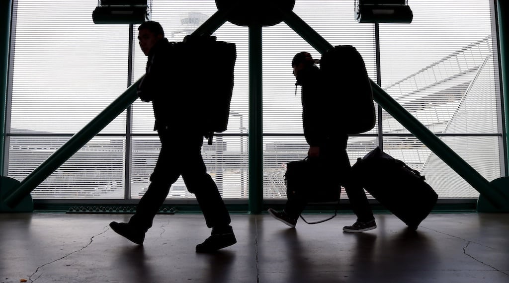 This Dec. 21, 2012 file photo shows travelers walking to a ticketing desk at O'Hare International Airport in Chicago. 