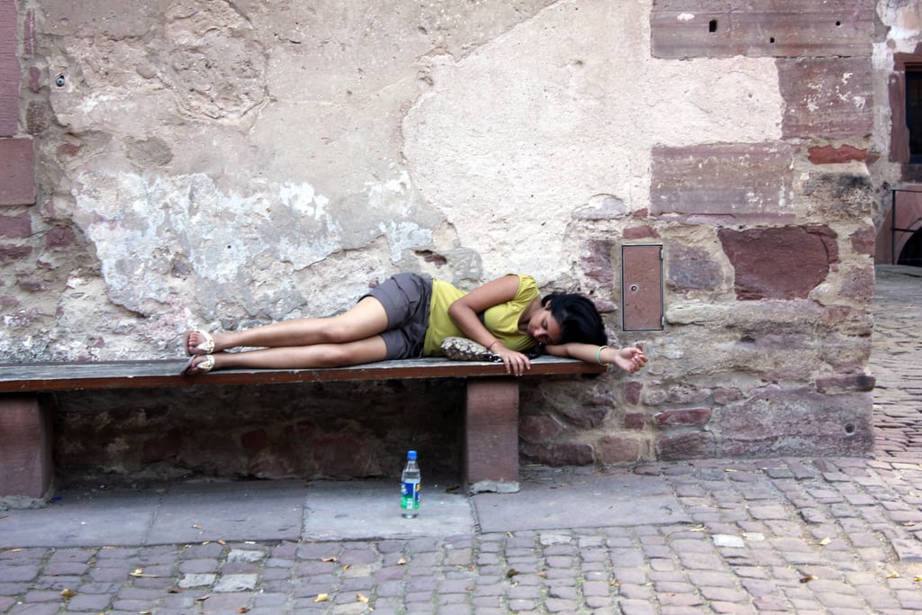 A tourist takes a nap on a bench at Heidelberg Castle in Germany