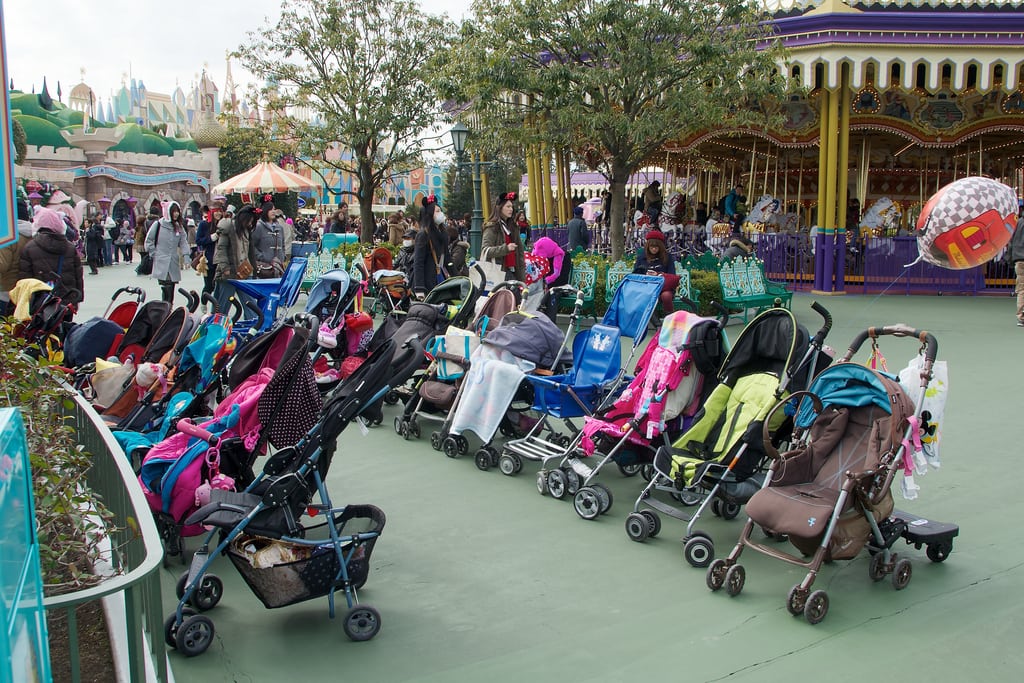 Disney attendants park strollers in neat rows outside of rides to be retrieved by families upon exit. 