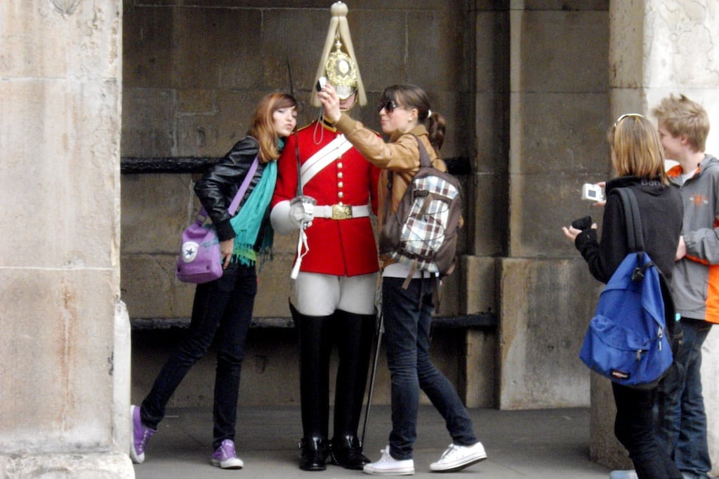 Tourists play with the guards at Buckingham Palace. 