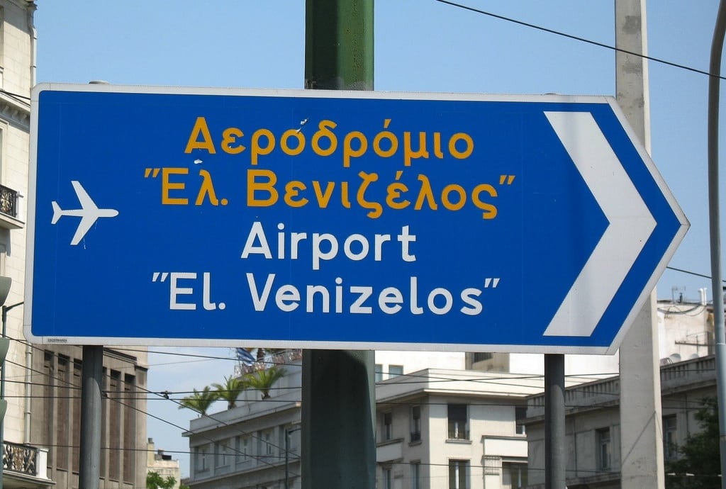 A sign pointing to Athens International Airport in Greece. 