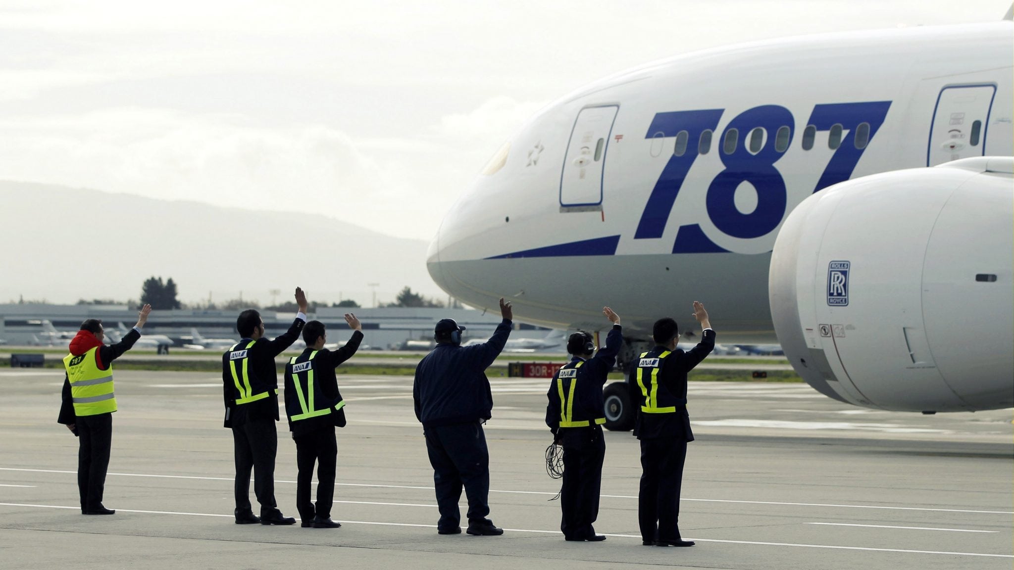 Grounds crew wave at an All Nippon Airways Boeing 787 Dreamliner as it departs San Jose International Airport for Tokyo in San Jose, California, on January 11, 2013. 