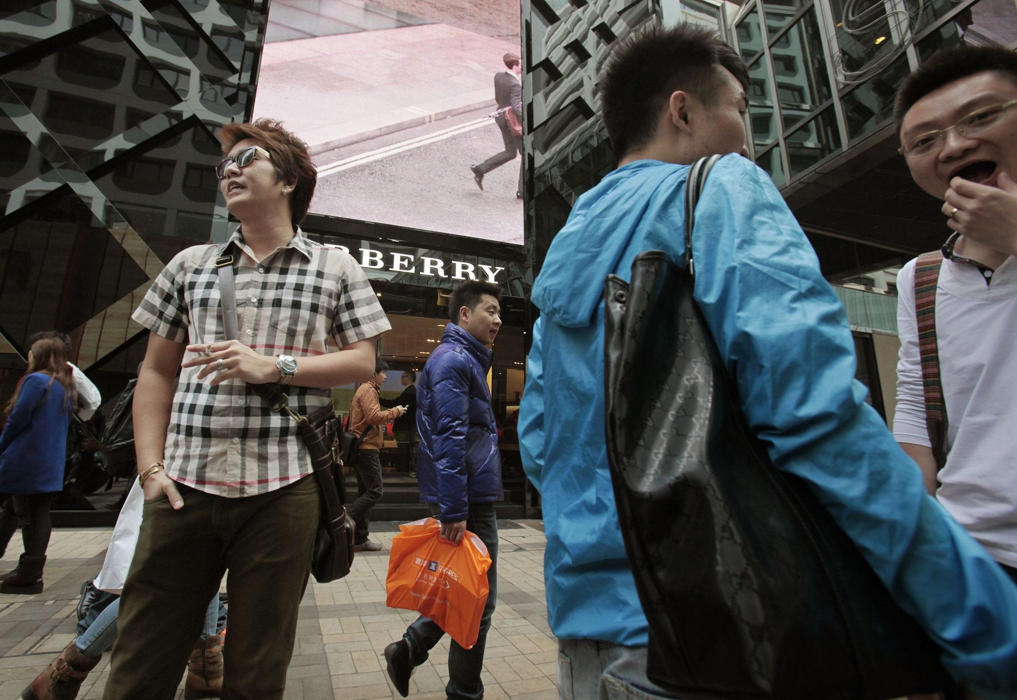 Mainland Chinese visitors stand outside a Burberry store at Tsim Sha Tsui shopping district in Hong Kong January 18, 2013. 
