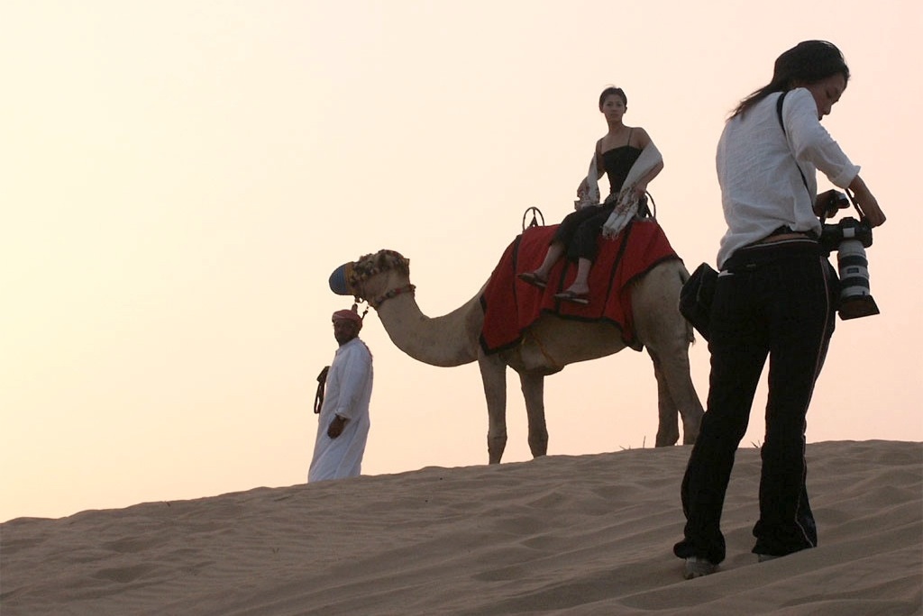 A tourist on a camel ride in the desert. 