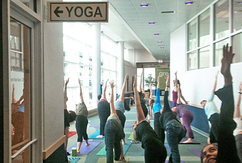 A local class does yoga at the Burlington International Airport in Burlington, Vt., to celebrate the grand opening of a yoga space for travelers. 