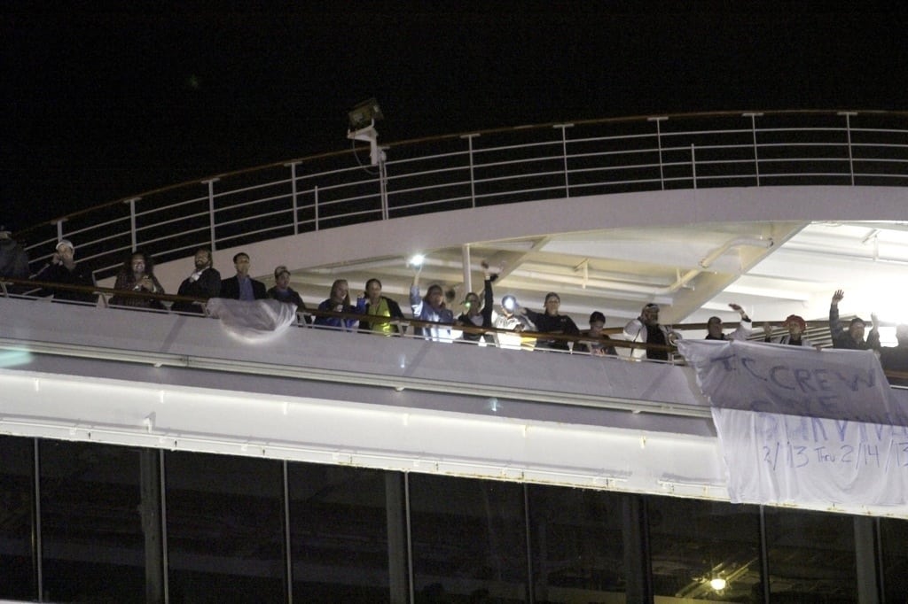 Passengers wait to leave the Carnival Triumph cruise ship after reaching the port of Mobile, Alabama, February 14, 2013. 