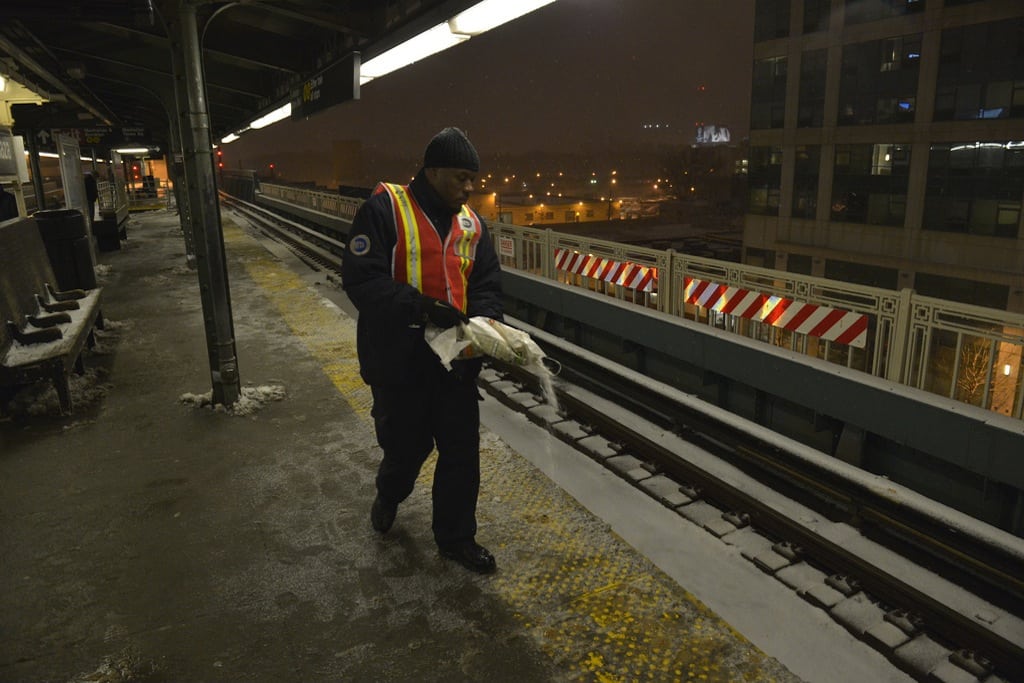 A MTA employee salts the platforms at Queensboro Plaza.