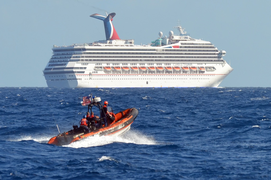 The Carnival Triumph cruise ship is towed towards the dock as spectators watch at the port of Mobile, Alabama, February 14, 2013. 