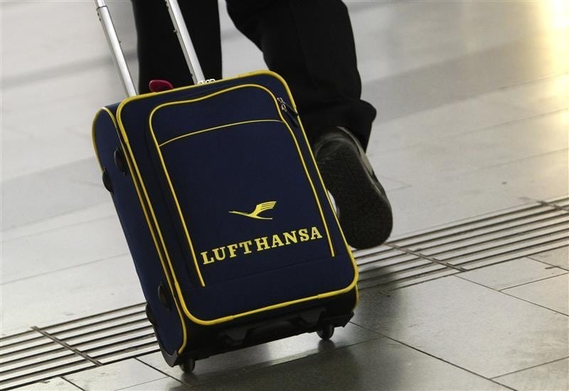  A man wheels a luggage bag with a Lufthansa logo in Vienna April 30, 2012. 