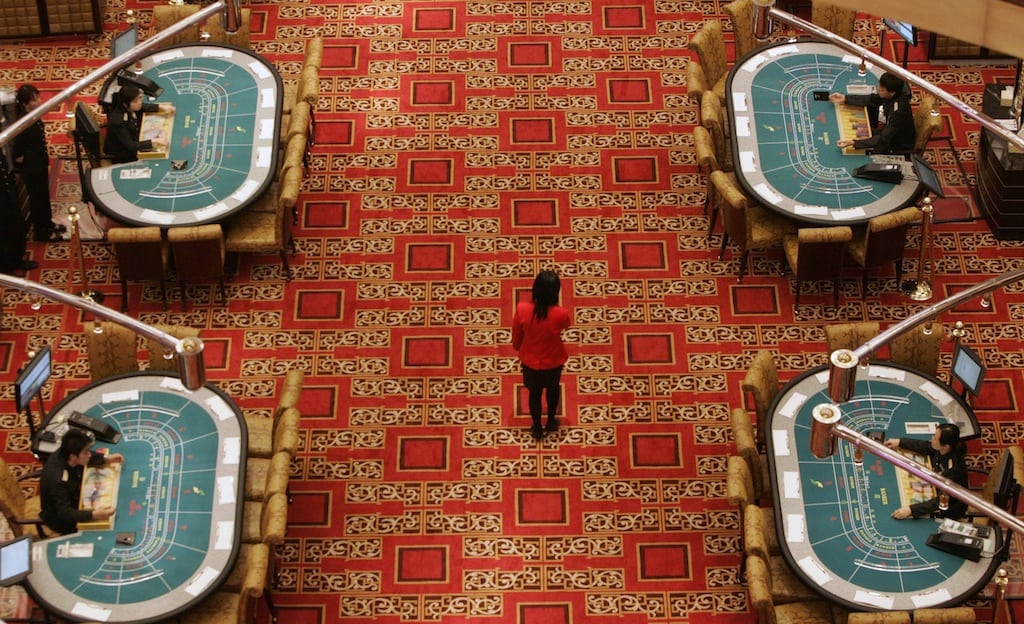 An employee walks past tables at SJM's flagship casino Grand Lisboa, owned by Macau tycoon Stanley Ho, before the opening ceremony in Macau in this February 11, 2007 file photo. 