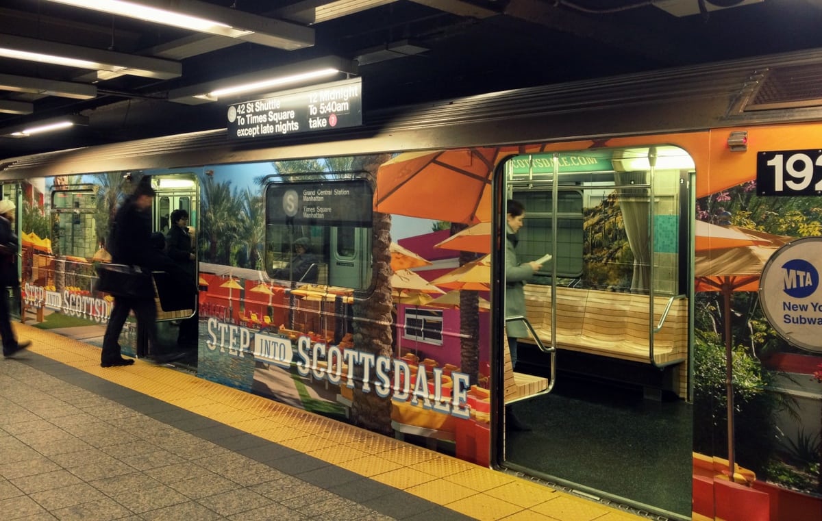 New Yorkers board the S train, which has been wrapped in an ad for spas in Scottsdale, Arizona. 