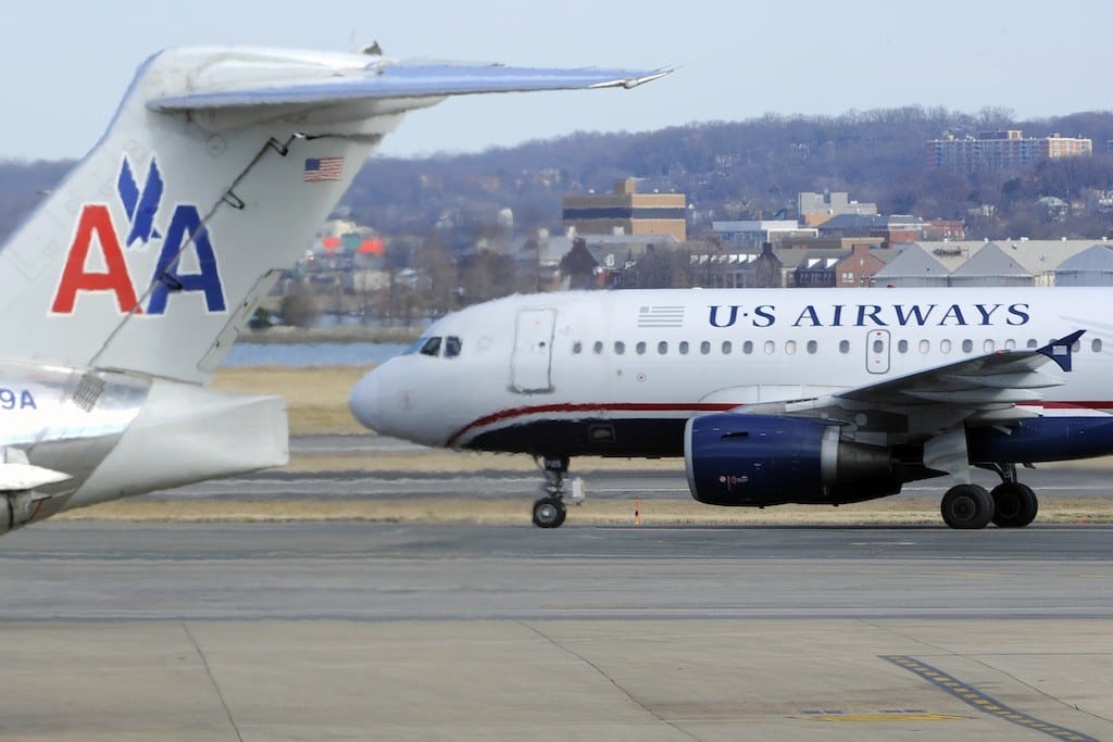 A US Airways plane (R) taxis for takeoff past an American Airlines plane at the Ronald Reagan Washington National Airport in Arlington County, Virginia, February 10, 2013.