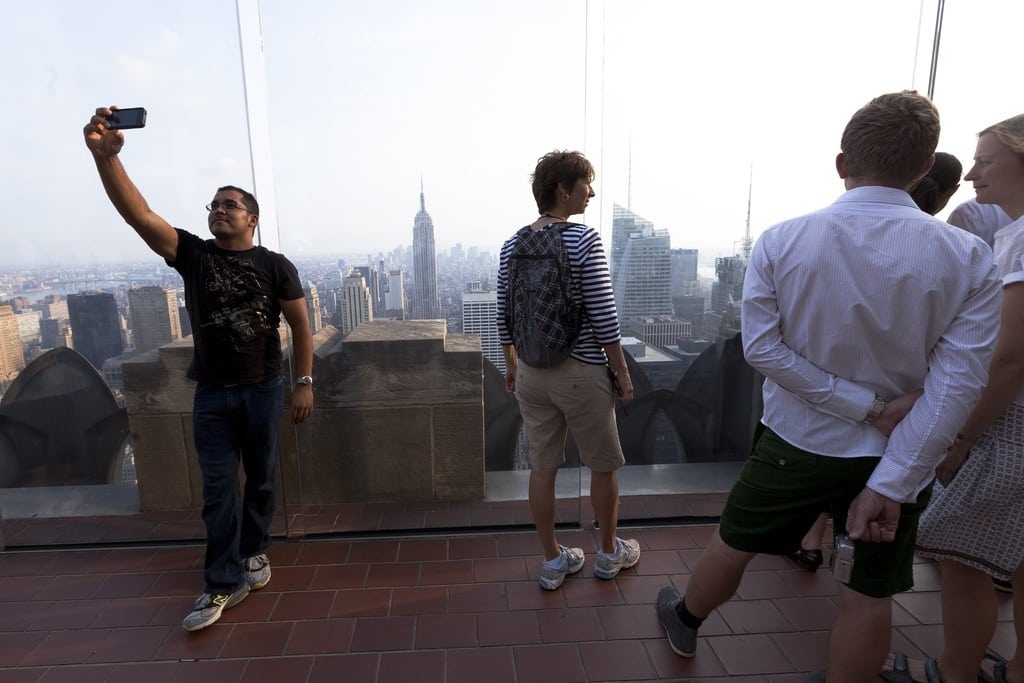 A tourist takes a self-portrait at the top of The Rock at Rockefeller Center in New York City. 