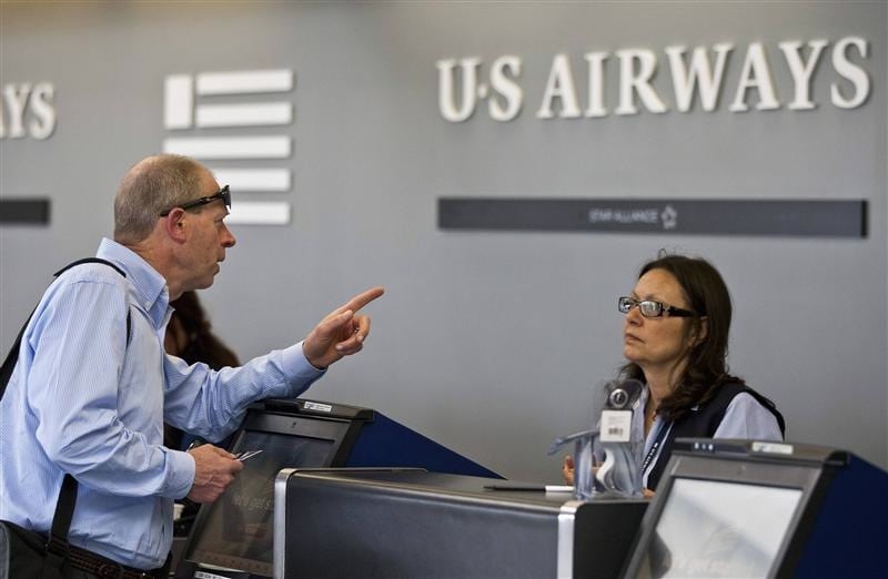 A US Airways passenger asks a question while checking in for his flight at Charlotte Douglas International Airport in Charlotte, North Carolina April 20, 2012. 