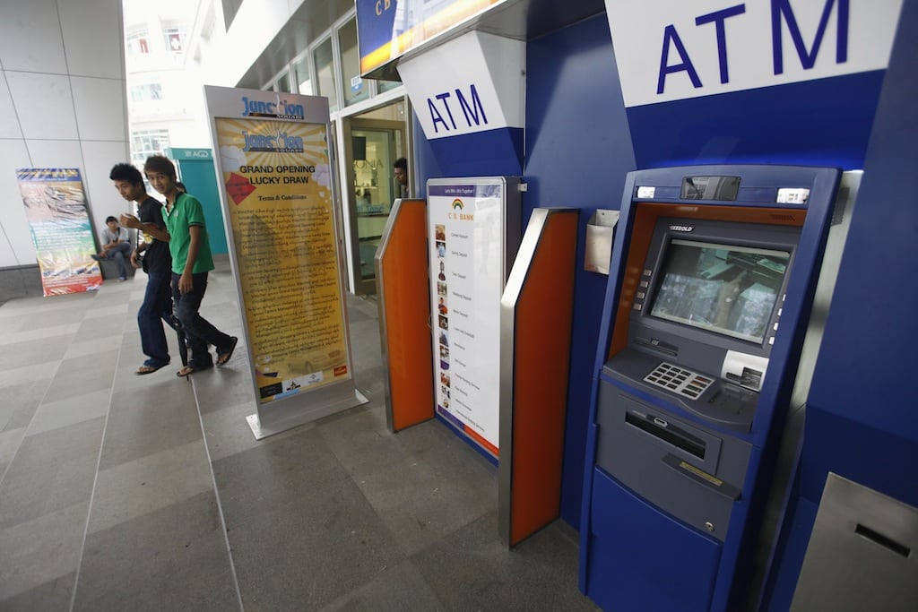 People walk past ATM machines at a shopping centre in Yangon, in this May 27, 2012 file photo. 