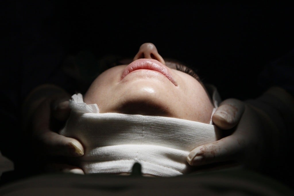 A woman lies on an operating table during a facelift surgery at a private plastic surgery clinic in Budapest, March 1, 2012. 