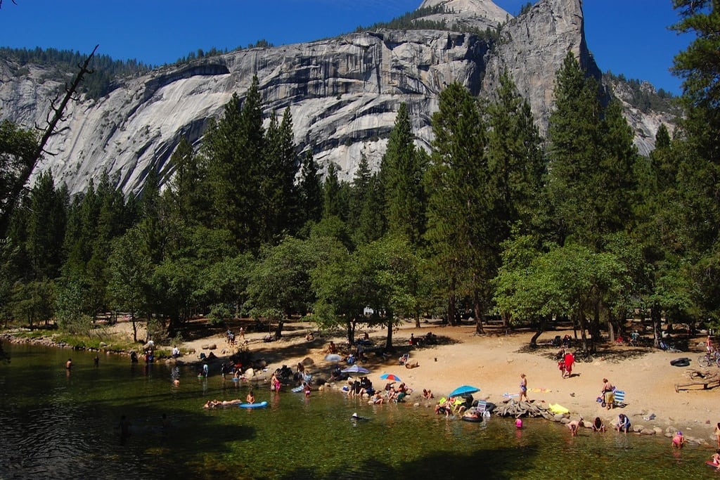 Visitors play at the beach on the Merced River in Yosemite National Park. 