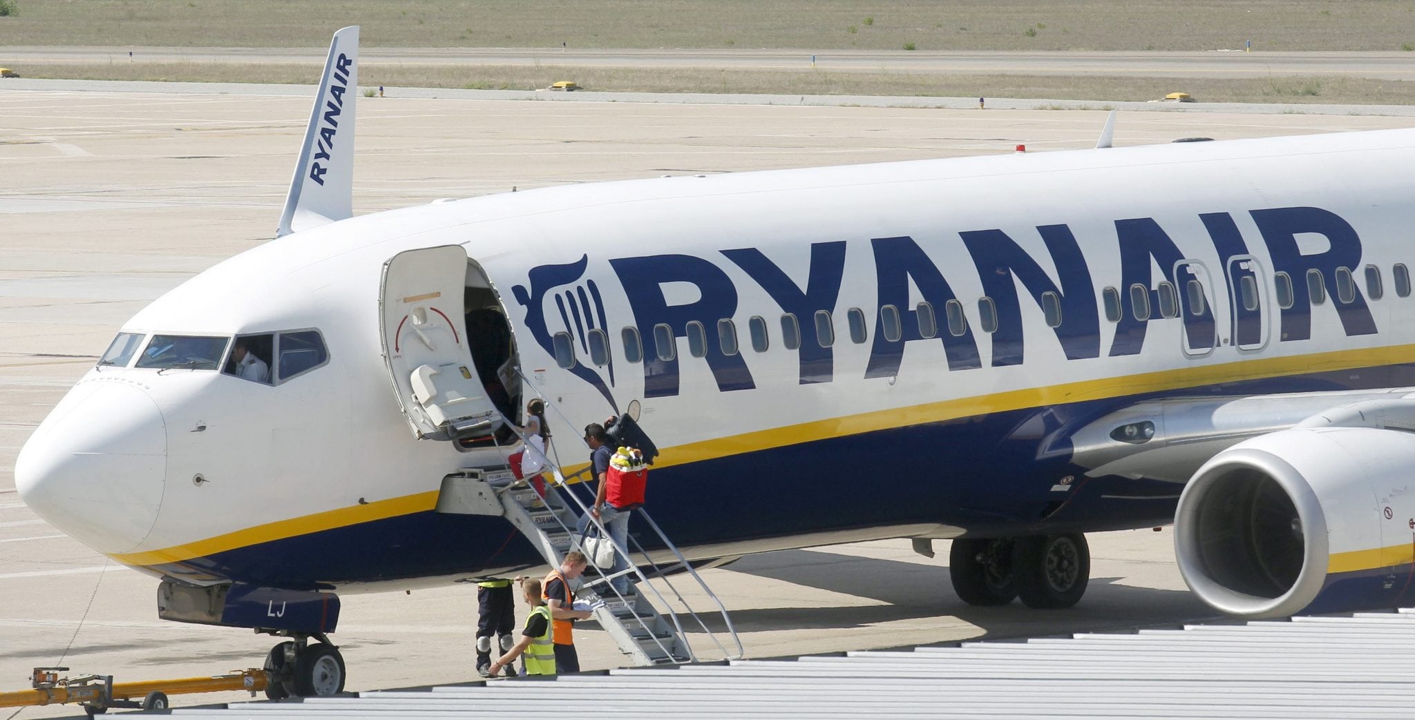 Passengers board a Ryanair plane parked at Girona airport, September 20, 2012. 