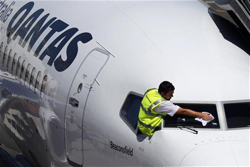 Ground crew member cleans the windshield of a Qantas passenger plane at Adelaide airport. 