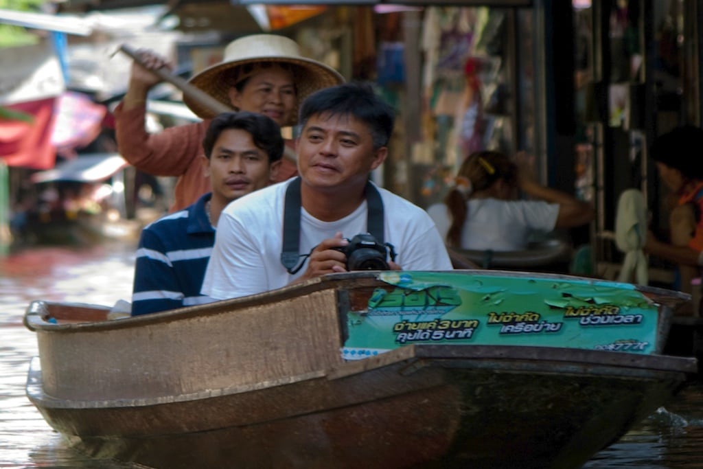 Visitors travel through the floating market on a tour in Thailand. 