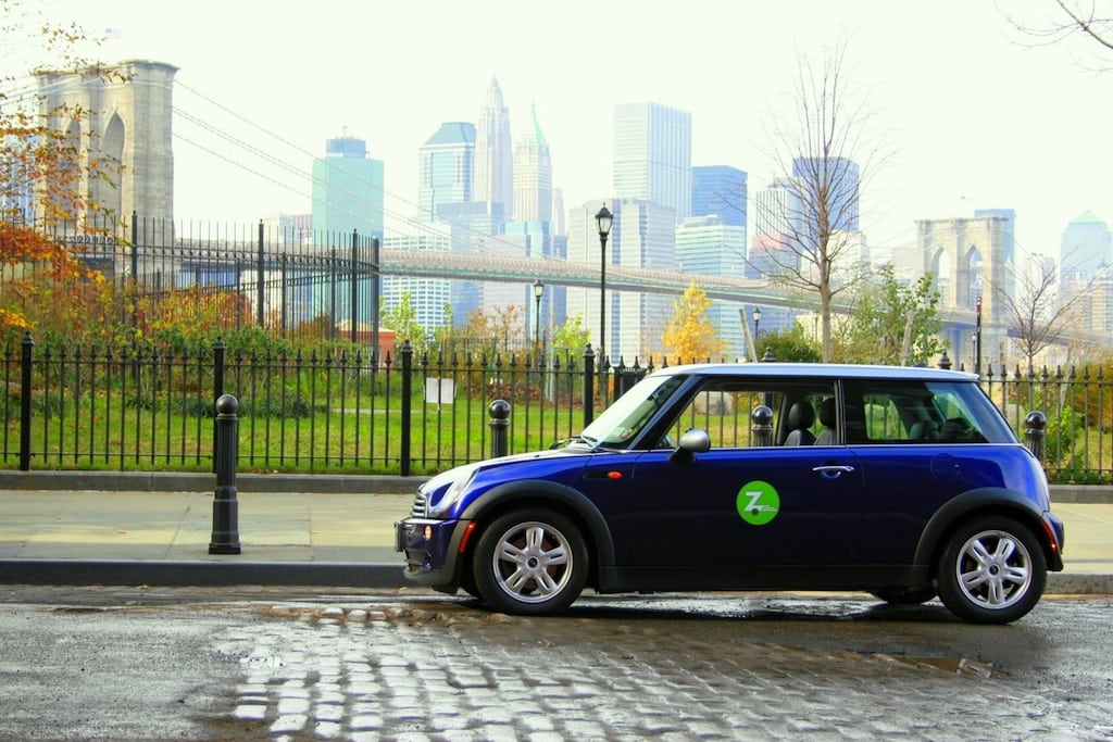 A Zipcar with Manhattan in the background.
