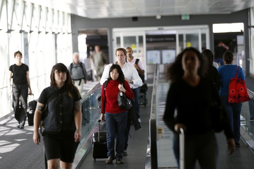 Airline passengers head to a flight at San Francisco International Airport in San Francisco, California, April 22, 2013. 