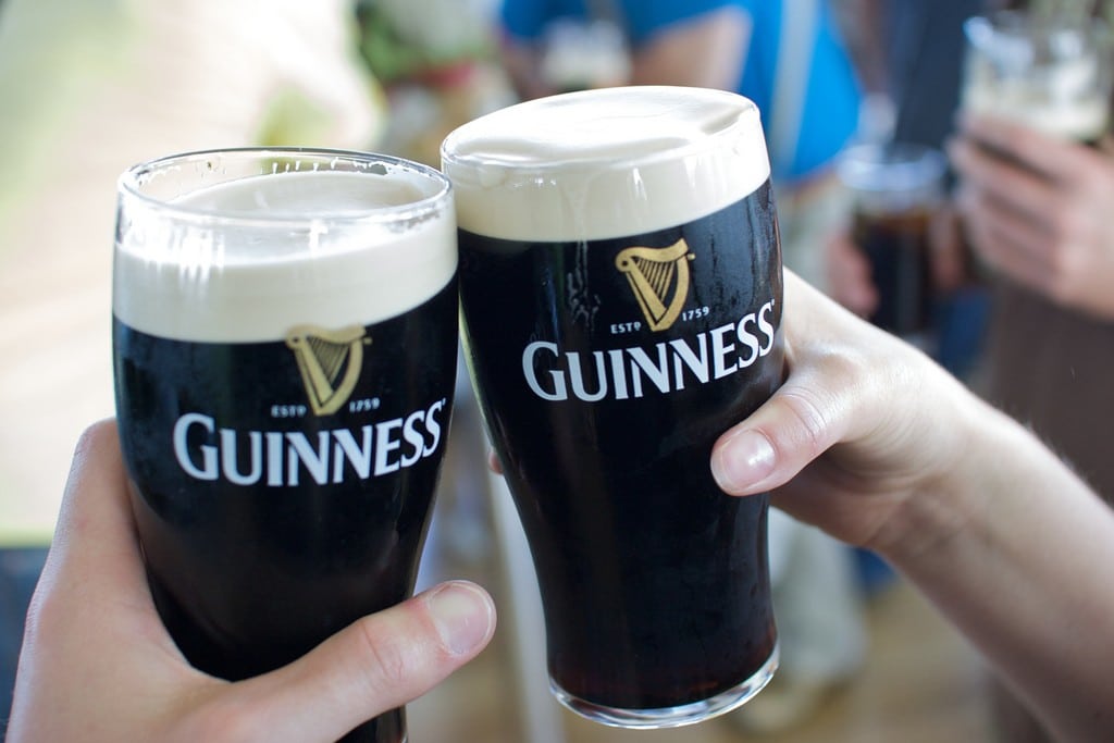 Two tourist cheers their Guinness glasses in Dublin, Ireland. 