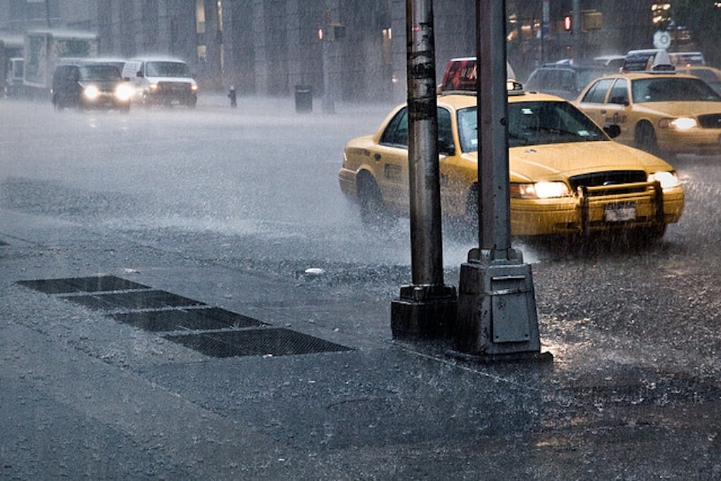 A taxi cuts through the rain in New York City. 