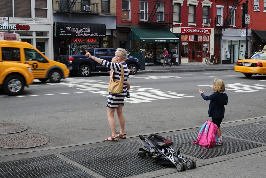 A mother and her daughters hail a taxi in the West Village of Manhattan. 