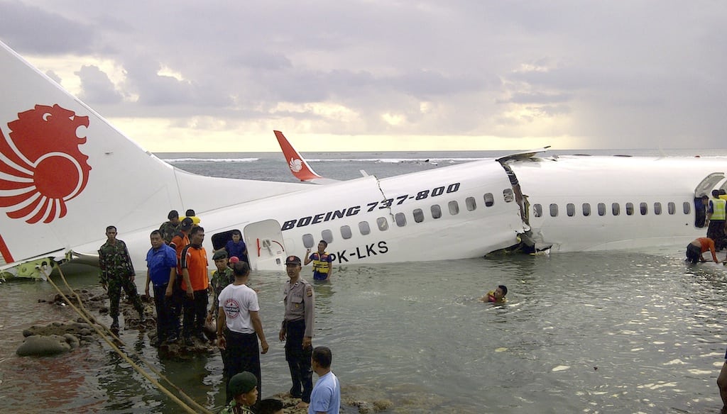 In this photo released by Indonesia's National Rescue Team, rescuers stand near the wreckage of a crashed Lion Air plane in Bali, Indonesia on Saturday, April 13, 2013. (Associated Press/National Rescue Team)