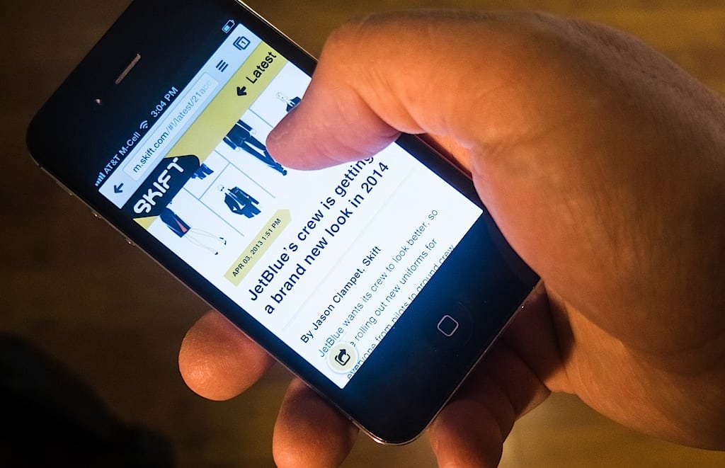An enthusiastic Skift reader checks the latest news on his smartphone. 
