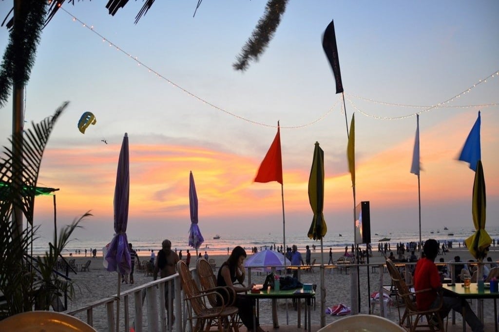 The sun sets in front of a restaurants on Colva Beach in Goa, India. 