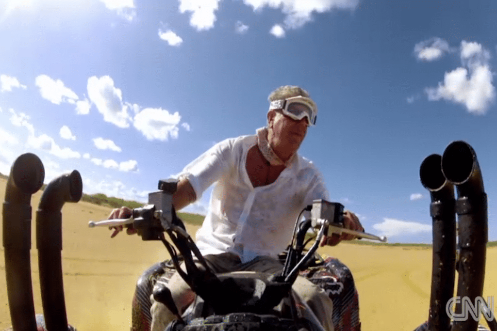 Anthony Bourdiain rides an ATV through rugged desert terrain in northern Colombia. 