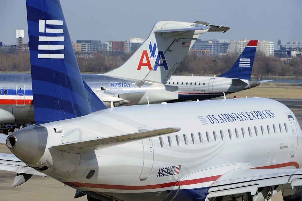 An American Airlines plane (C) is seen between two US Airways Express planes at the Ronald Reagan Washington National Airport in Arlington County, Virginia. 