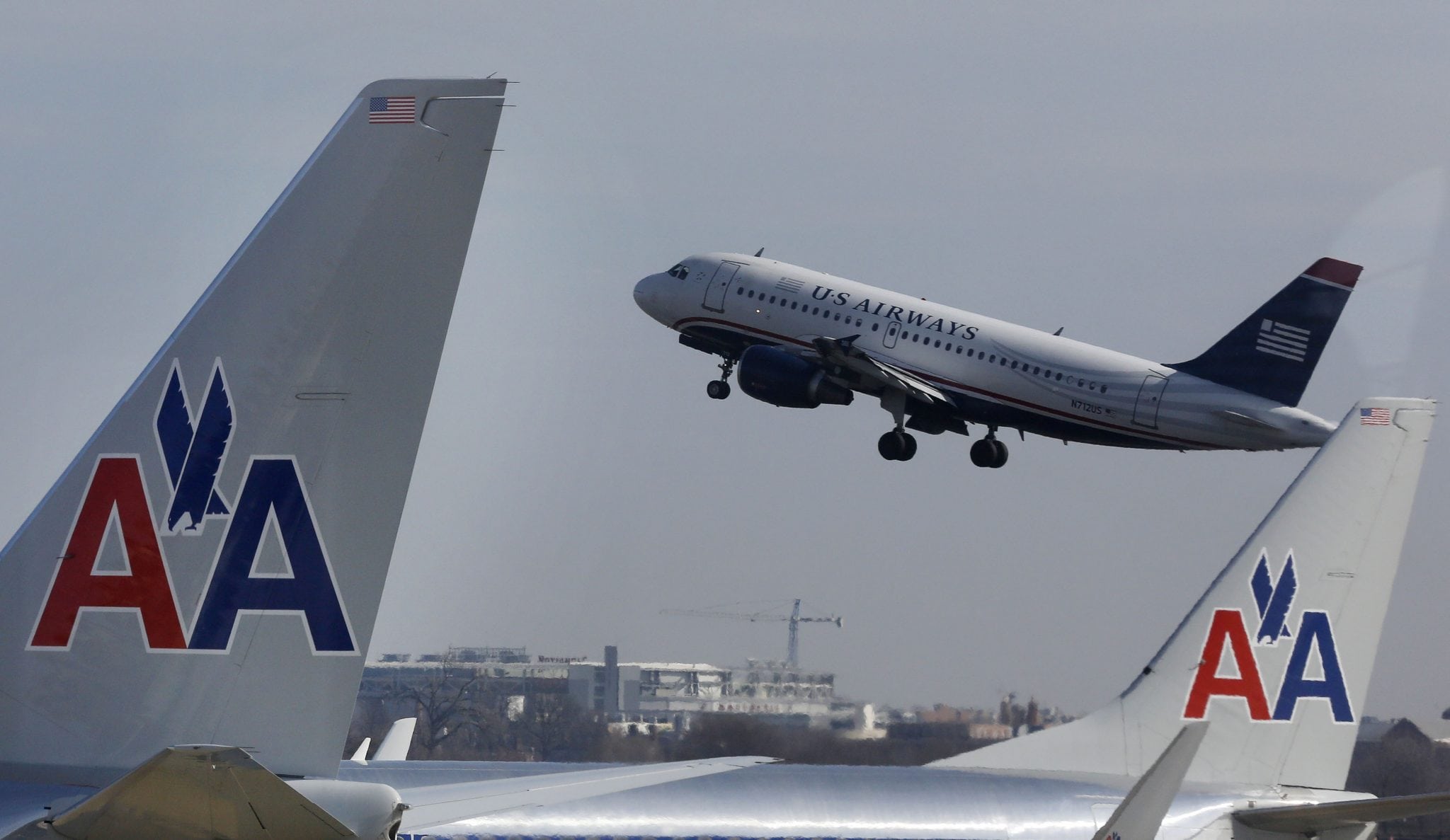 A U.S. Airways jet departs Washington's Reagan National Airport next to American Airlines jets outside Washington, February 25, 2013. 
