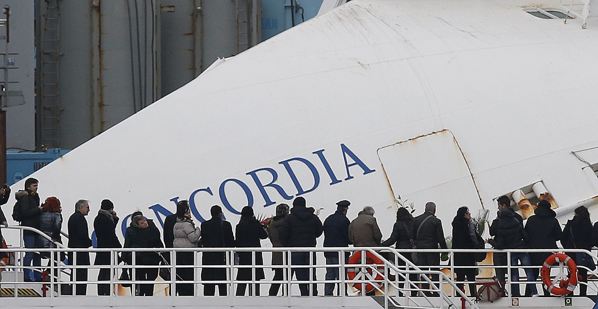 Relatives of victims stand on a ferry in front of the capsized cruise liner Costa Concordia outside Giglio harbour. 