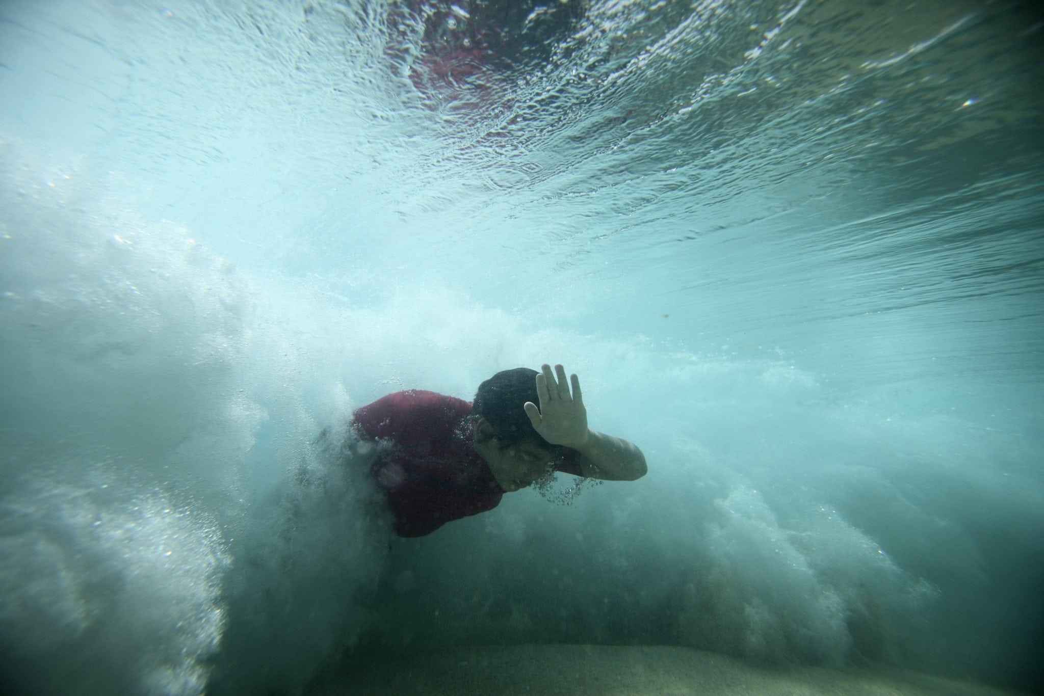 A bodysurfer punches through a wave at the Ehukai sandbar near the surf break known as 'Pipeline' on the North Shore of Oahu, Hawaii. 