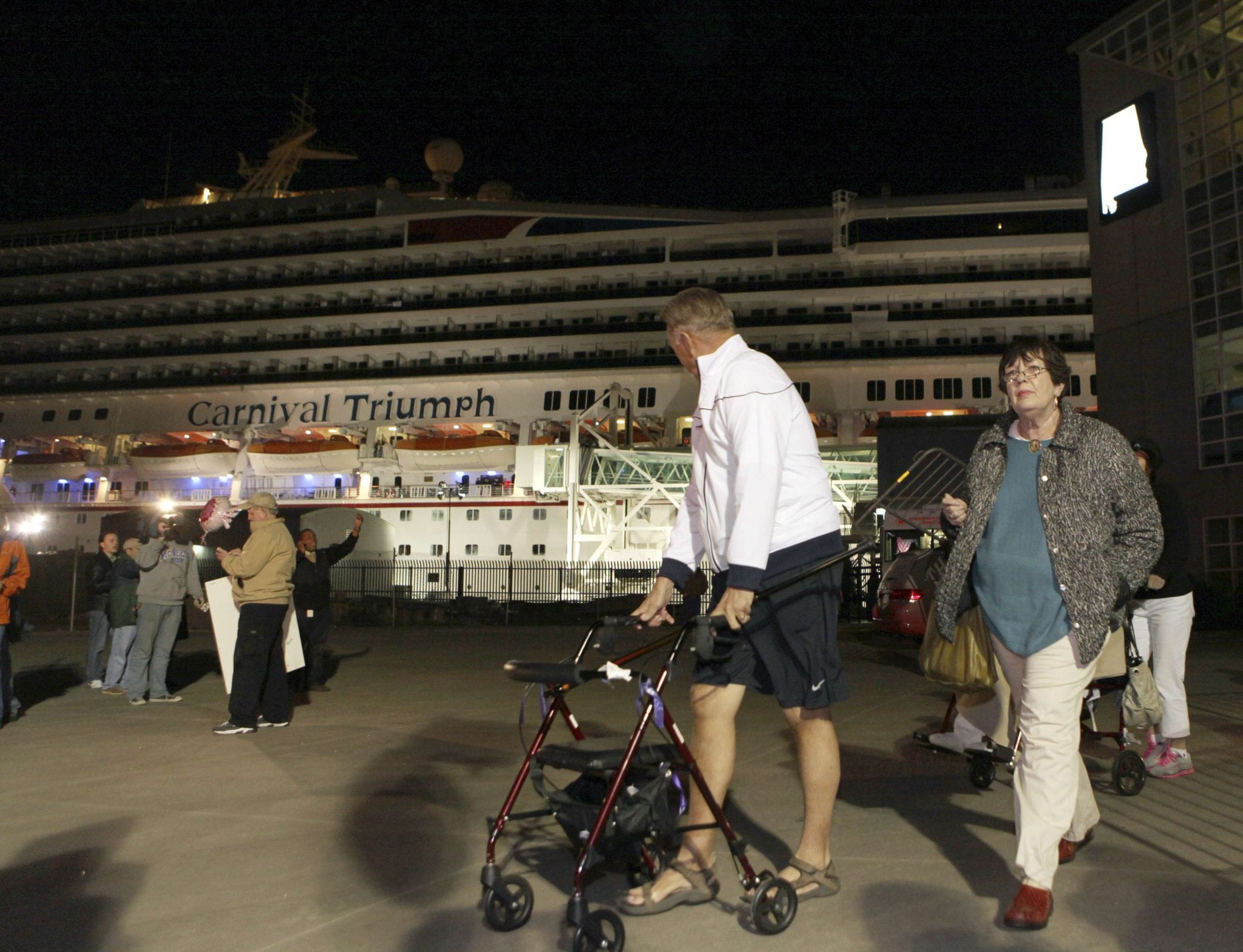 Passengers leave the Carnival Triumph cruise ship after reaching the port of Mobile, Alabama. 