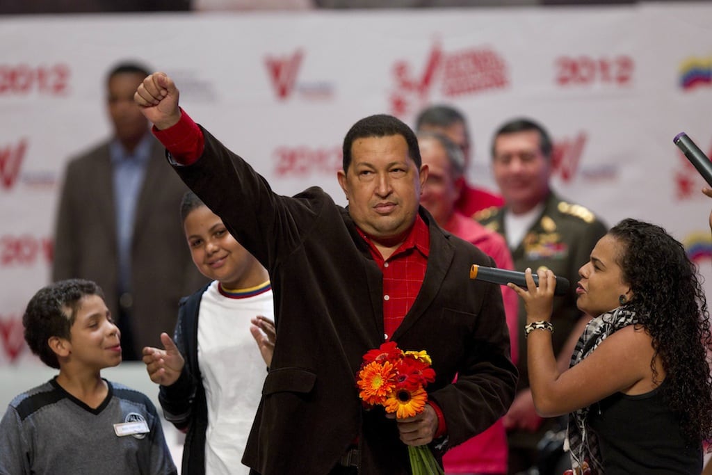 Venezuela's President Hugo Chavez gestures as rap singer Rodbexas, right, sings during an event at Teresa Carreno theater in Caracas, Venezuela, Thursday March 29, 2012. 