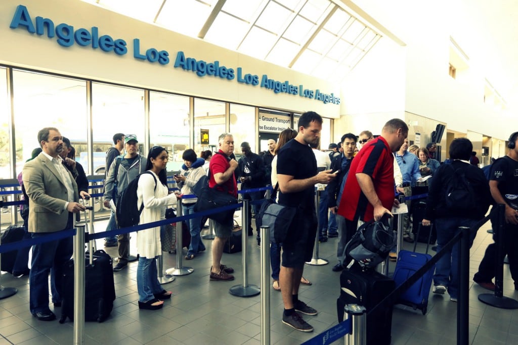 Travelers standing in line at the LAX International Airport in Los Angeles.
