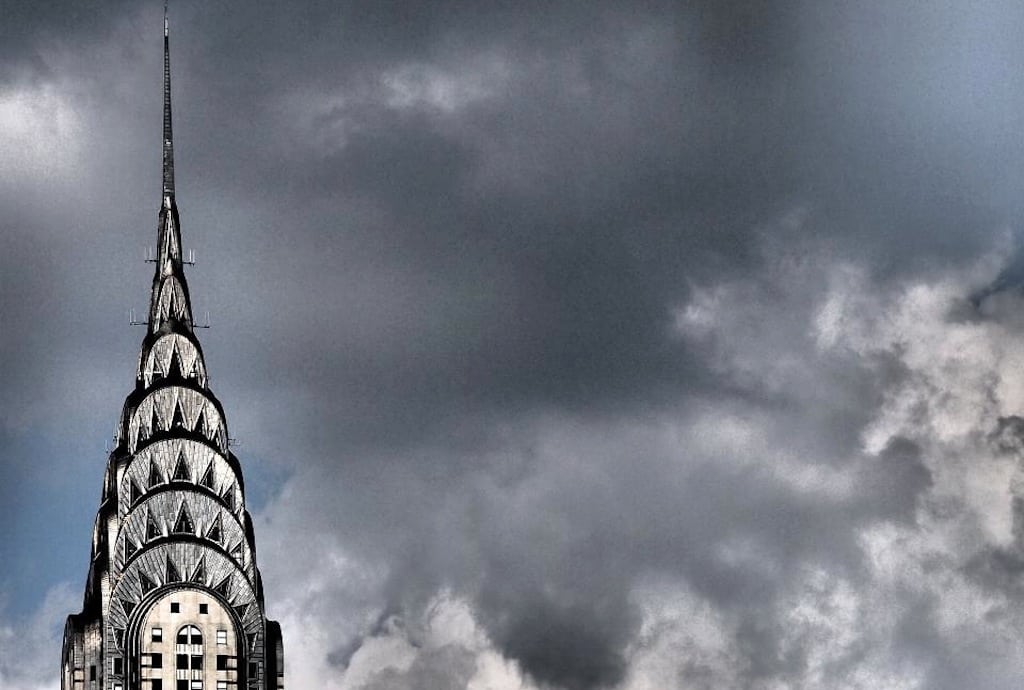The top of the Chrysler Building in front of a stormy sky. 